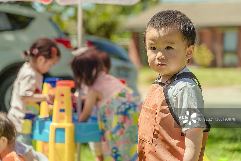 花园别墅草坪上一起玩水游戏的孩子们图片素材