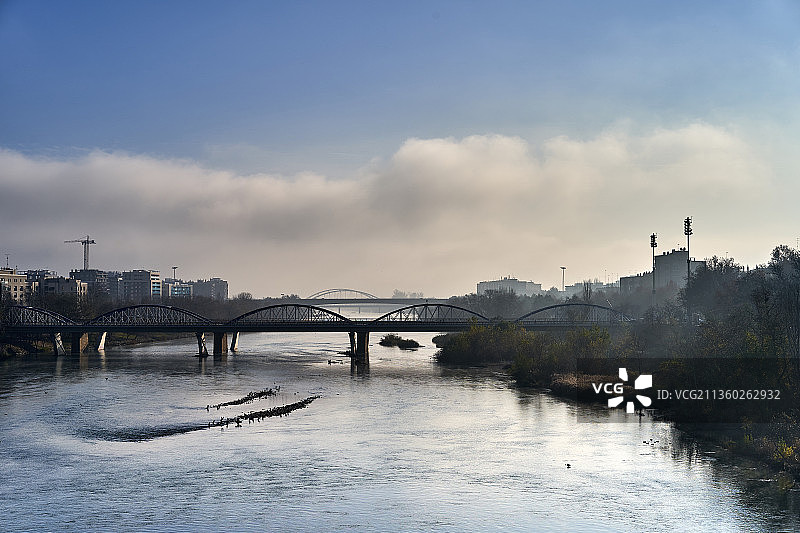 埃布罗河上的桥梁，多云天空下的河流桥梁景观图片素材