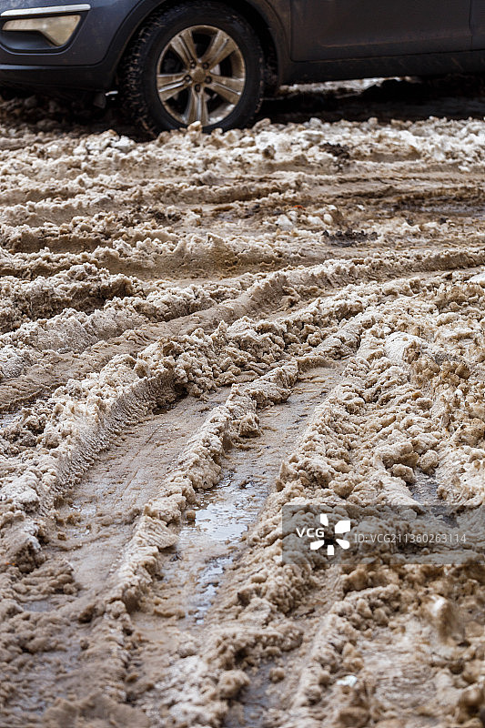 冬季街道上带有车轮印的厚厚肮脏湿雪层图片素材
