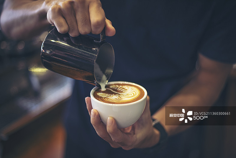 咖啡师往咖啡杯中倒入牛奶图片素材