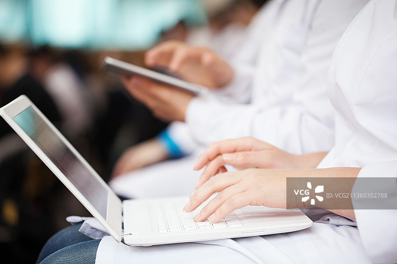 参加会议的医生带着笔记本电脑和平板电脑图片素材