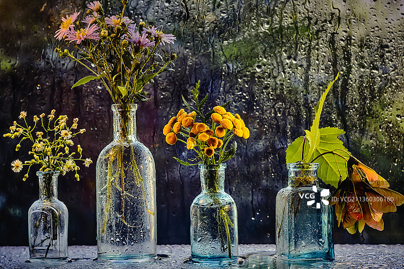 蓝色玻璃、明亮的花朵和雨滴图片素材