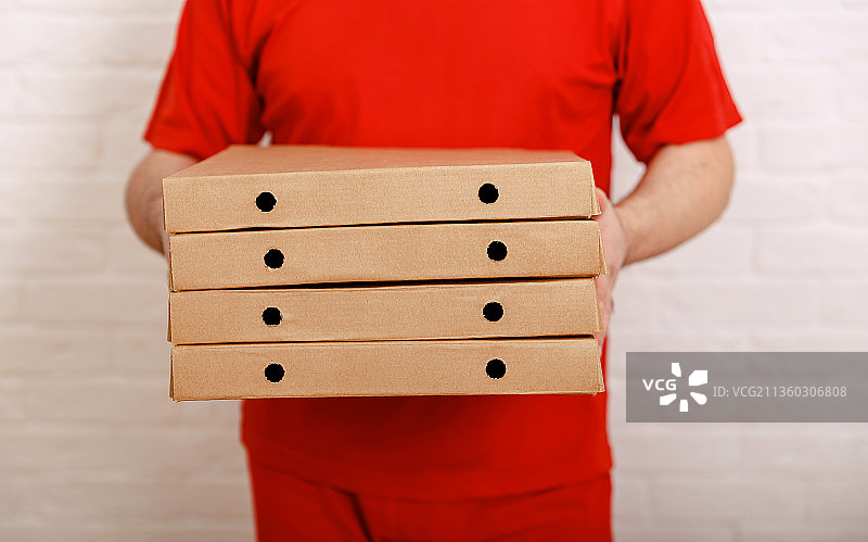 拿着盒子的披萨外卖员，城市里最快的披萨外卖图片素材