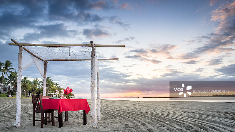 坐在海滩秋千上面对天空的女人图片素材