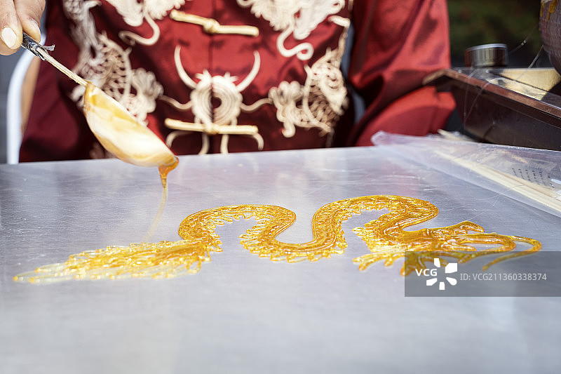 民族艺人制作特色美食龙纹糖画图片素材