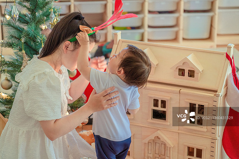 圣诞之夜小男孩与妈妈分享节日快乐场景图片素材