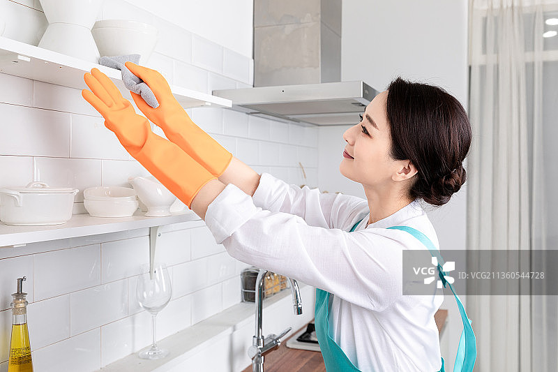 亚洲妇女穿着白衬衫和围裙，从事专业的家庭清洁服务工作图片素材