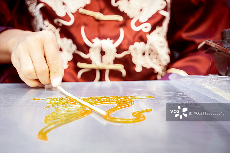 传统唐装糖人手艺制作天鹅状糖人图片素材