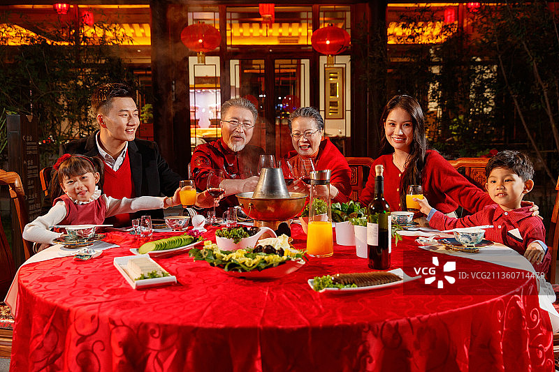 东方家庭在中式庭院内干杯庆祝新年图片素材
