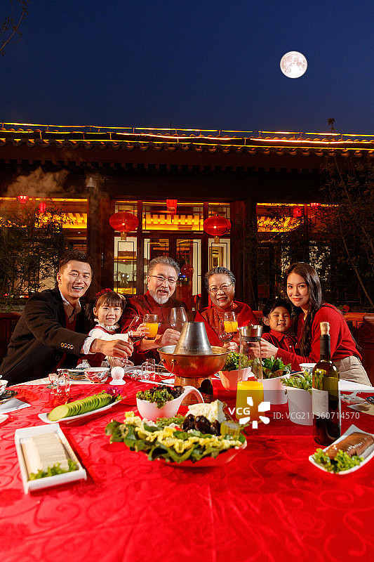 东方家庭在中式庭院内干杯庆祝新年图片素材