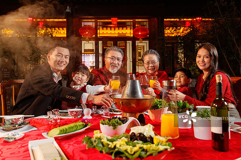 东方家庭在中式庭院内干杯庆祝新年图片素材
