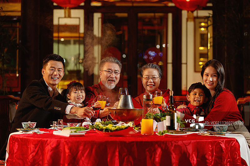 东方家庭在中式庭院内干杯庆祝新年图片素材