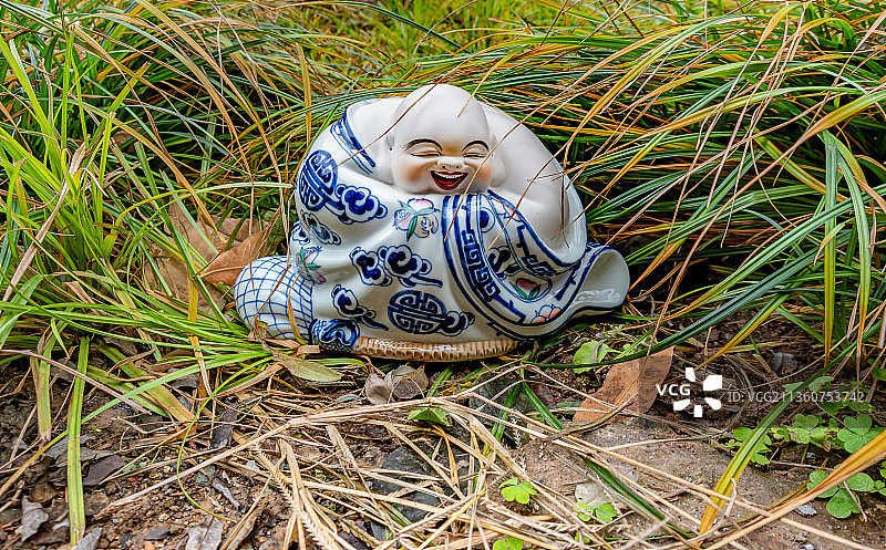 草丛中的青花瓷弥勒佛像图片素材