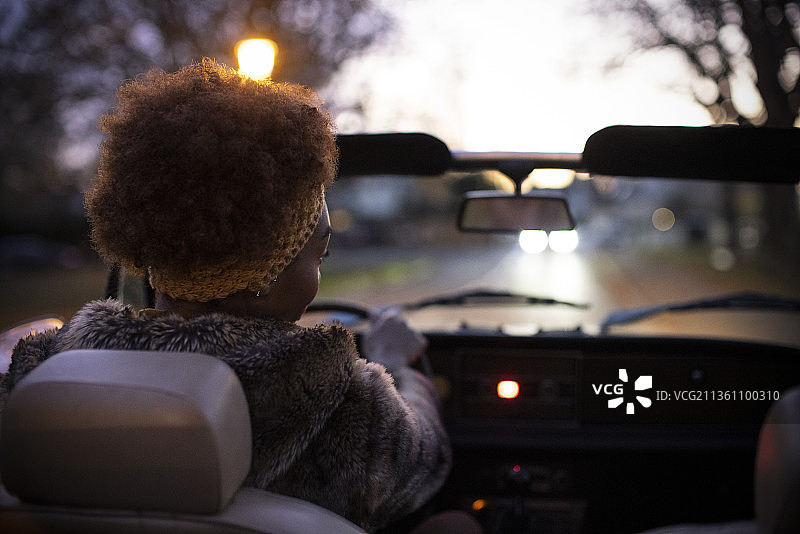 年轻女子在黄昏时驾驶敞篷车图片素材