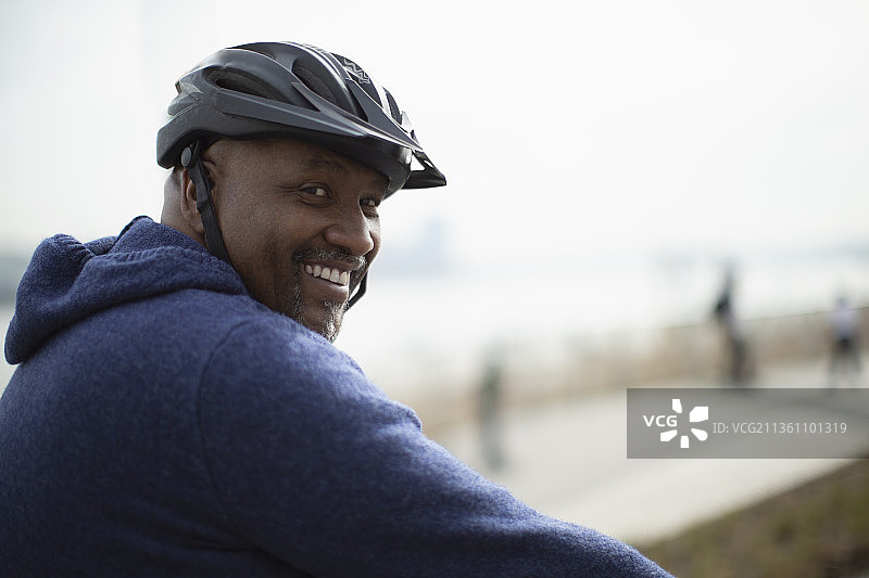 戴着自行车头盔的快乐男子肖像图片素材