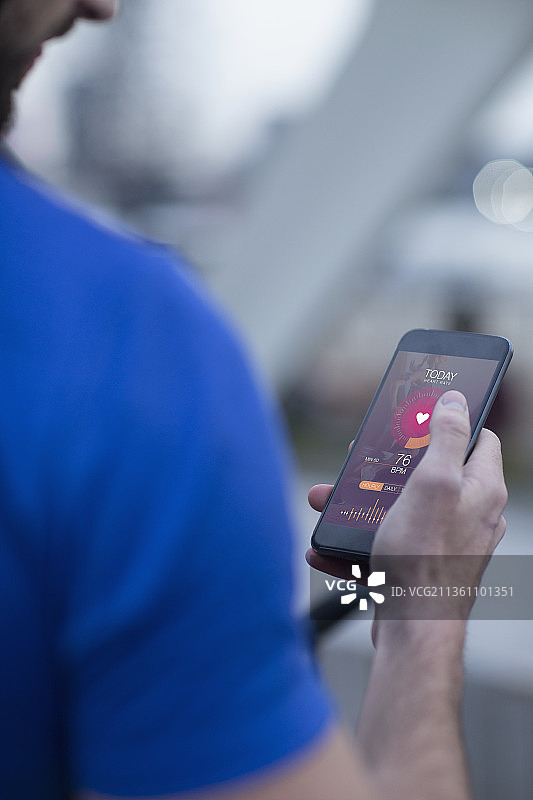 男人在智能手机应用上查看心率图片素材