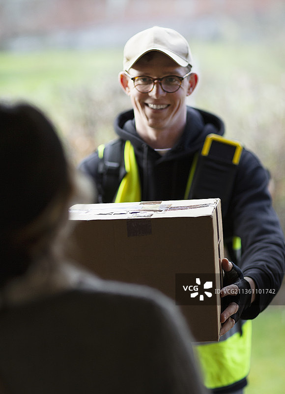 友好的快递员在门口送包裹图片素材