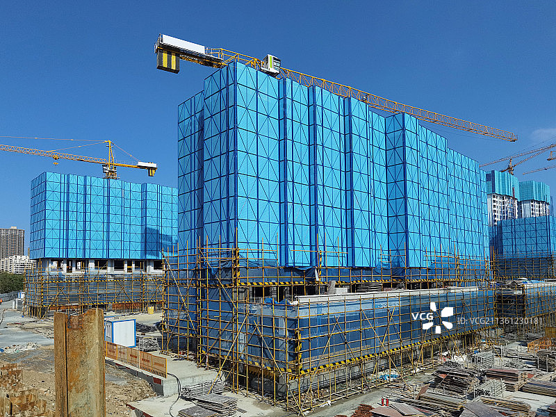 整洁的现代工地富有美感的整齐的蓝色米字格脚手架以及塔吊图片素材