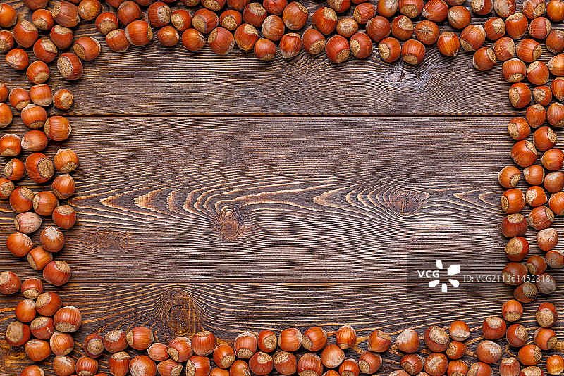 棕色木质背景上的榛子长方形框架图片素材