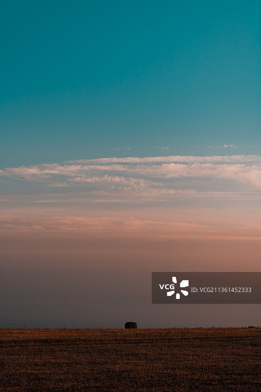 日落时分意大利钦戈利田野风光与干草捆图片素材