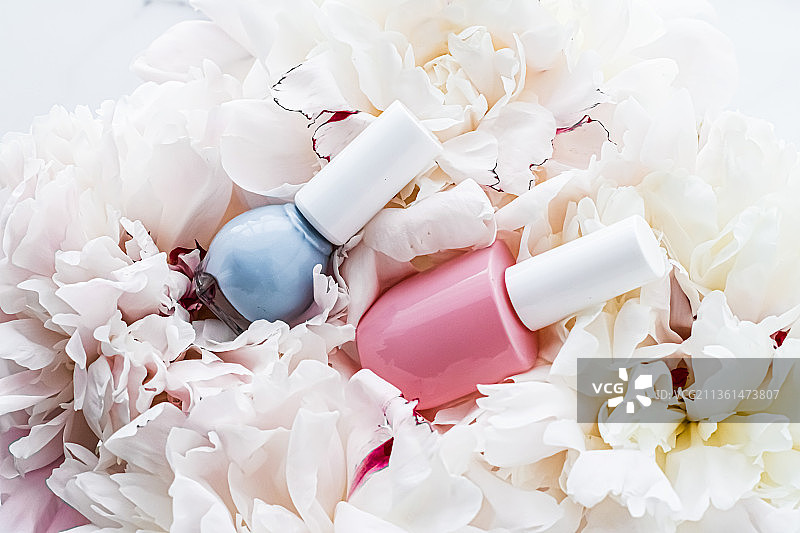 花卉背景上的指甲油瓶，法式美甲和化妆品图片素材