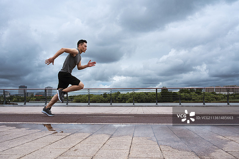 年轻男子下雨天户外跑步锻炼图片素材