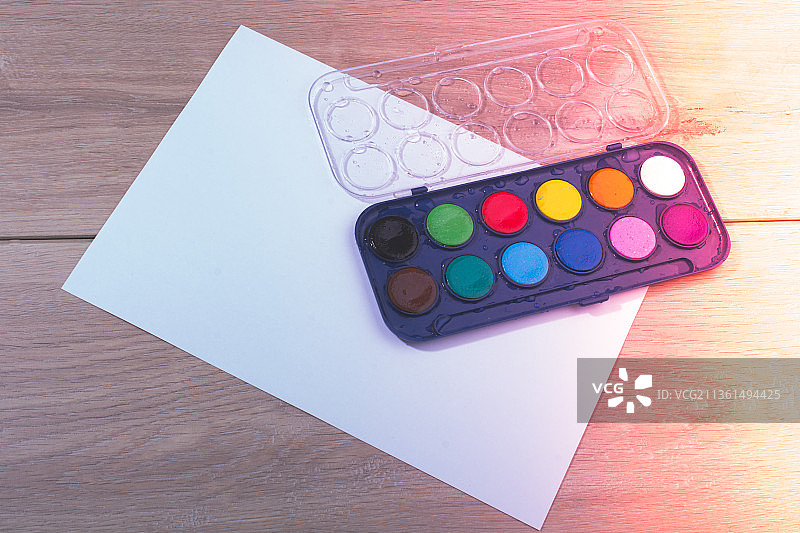 水彩颜料盒，纸张和木质背景图片素材