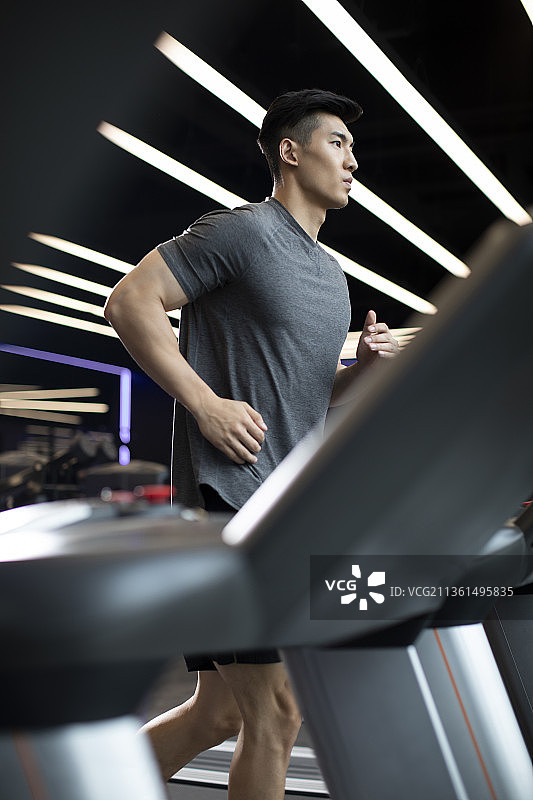年轻男士在健身房跑步图片素材