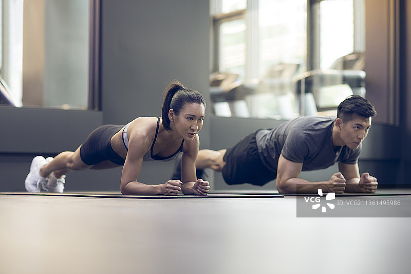 年轻情侣在健身房健身图片素材