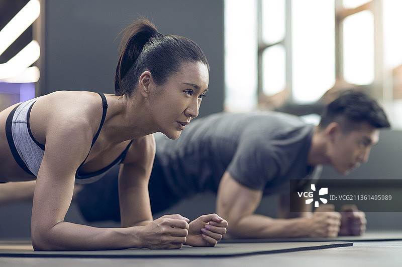 年轻情侣在健身房健身图片素材