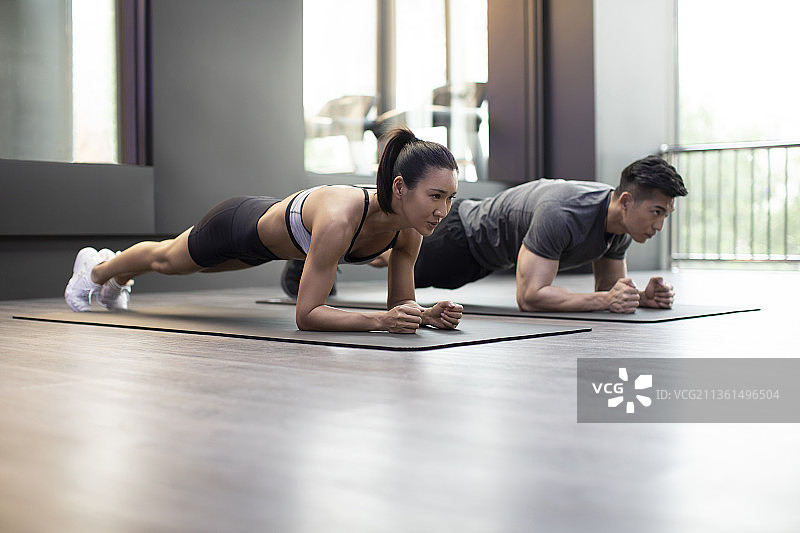 年轻情侣在健身房健身图片素材