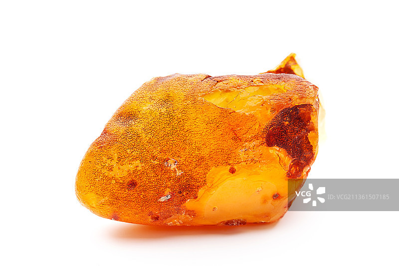 天然琥珀：白色背景上的一块黄色不透明天然琥珀图片素材