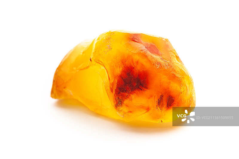 天然琥珀：白色背景上的一块黄色不透明天然琥珀图片素材