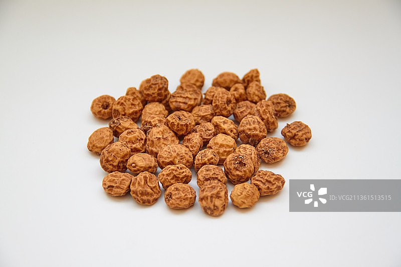 白色背景下的带壳油莎豆，西班牙油莎豆被称为chufa图片素材