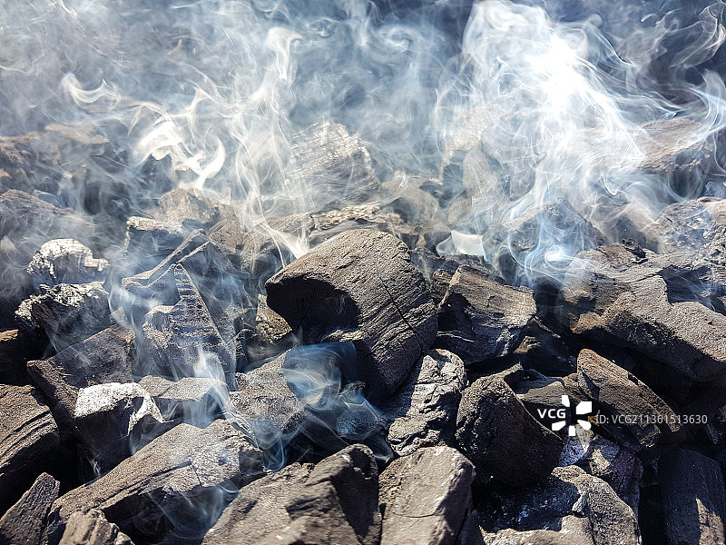 煤炭在炭火上燃烧的烟雾，为户外烧烤准备的火图片素材