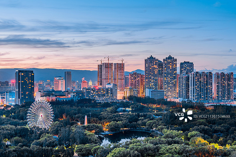 中国内蒙古呼和浩特青城公园摩天轮和城市天际线夜景图片素材