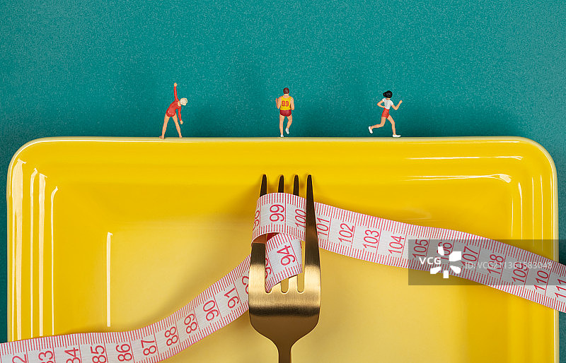 微缩创意餐盘里的叉子卷尺与慢跑健身的人群图片素材