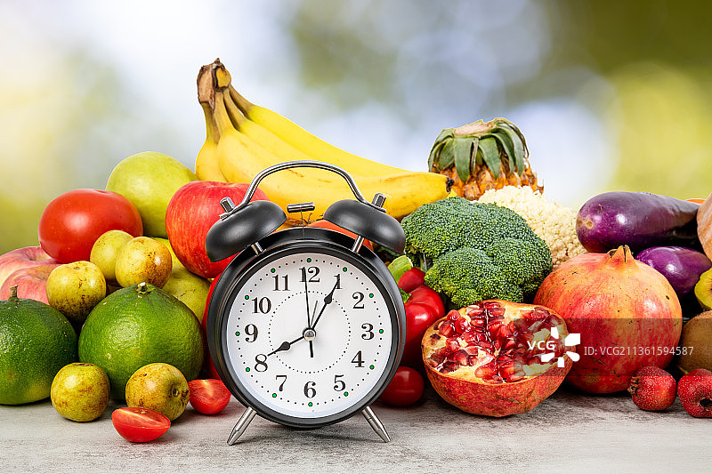 一个闹钟和丰富多种的新鲜蔬菜水果图片素材
