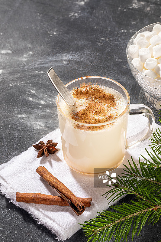 传统圣诞饮品蛋奶酒，在黑色背景白色餐巾上的玻璃杯中（俄罗斯）图片素材