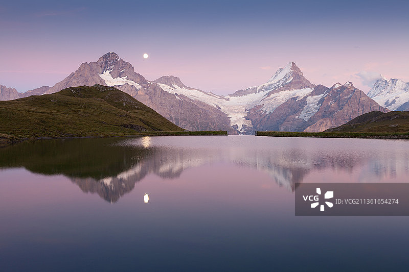 瑞士阿尔卑斯山：日落时分湖泊和山脉的壮丽景色，位于伯尔尼高地图片素材