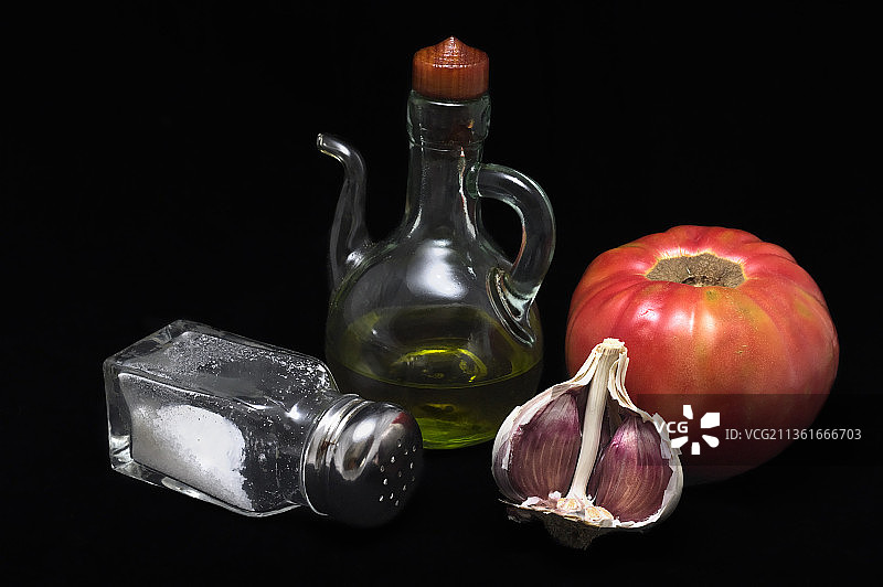 深色背景上的油、大蒜、番茄和盐（西班牙瓦伦西亚卡塔罗哈）图片素材