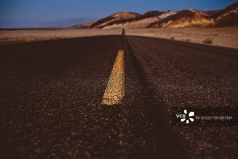 通往荒芜之地的道路：美国加利福尼亚州因约县的空旷公路景观图片素材