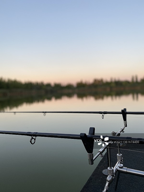 日落时分天空背景下的钓鱼竿特写图片素材