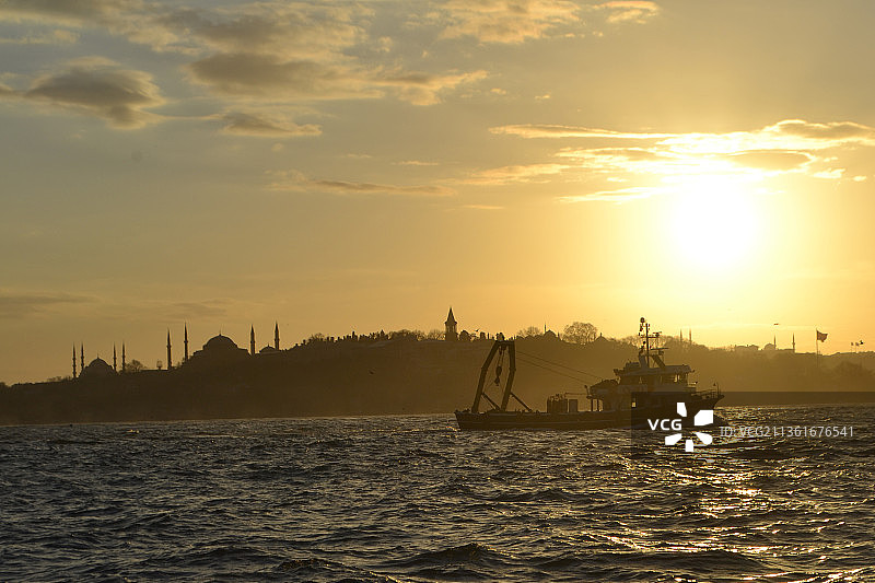 日落时分，海面上船只的剪影图片素材