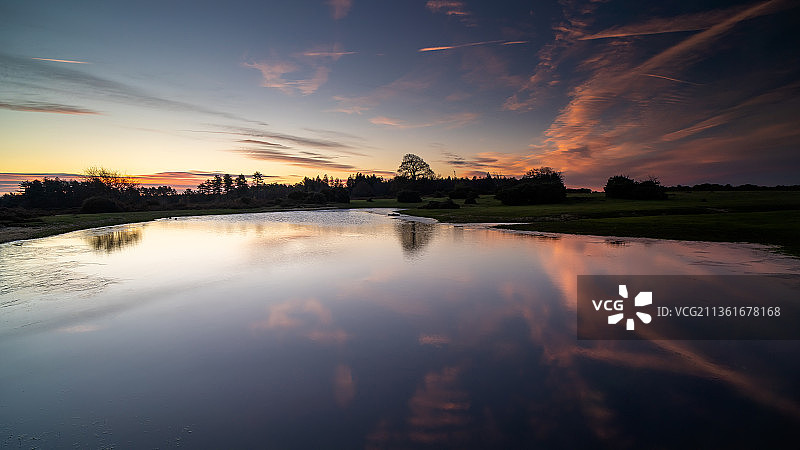 莫格谢德倒影：英国林德赫斯特明斯特德的日落时分湖景图片素材