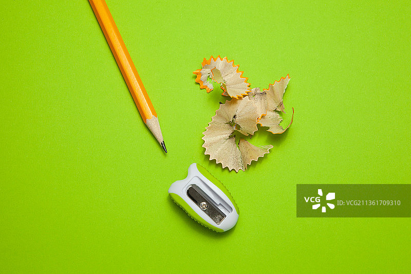 绿色背景上的削尖的铅笔和卷笔刀图片素材