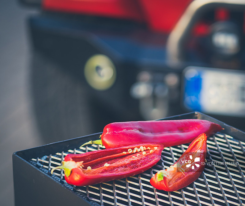 烤架上的切片辣椒，红色汽车背景特写图片素材