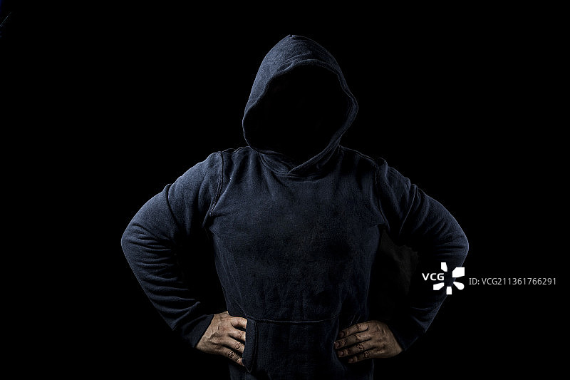 一个黑衣人在黑暗背景中图片素材