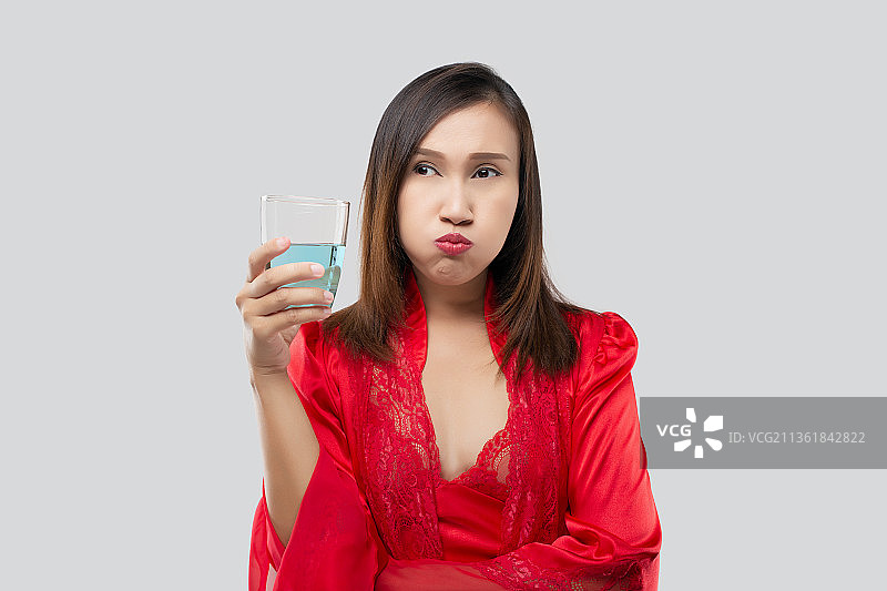 女人漱口，年轻女人拿着玻璃杯的肖像，白色背景图片素材