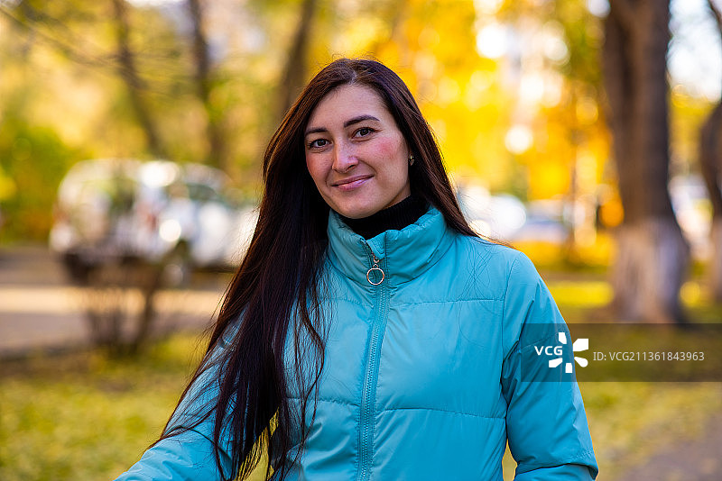秋日漫步：公园里微笑的年轻女子肖像，俄罗斯图片素材
